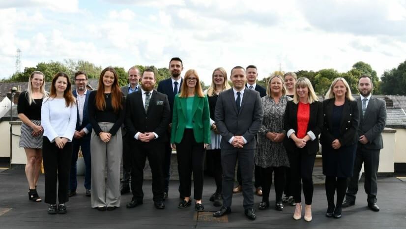A group of people standing in business attire