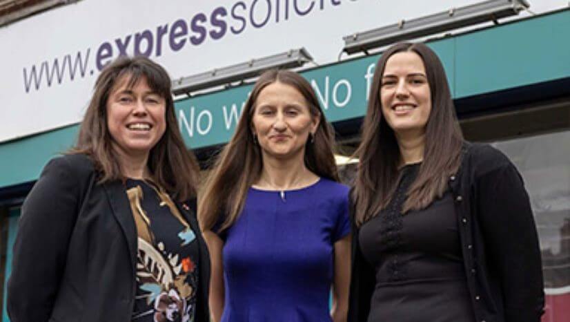 Three women standing smiling