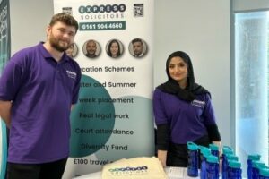 Two people stood by a table at law fair